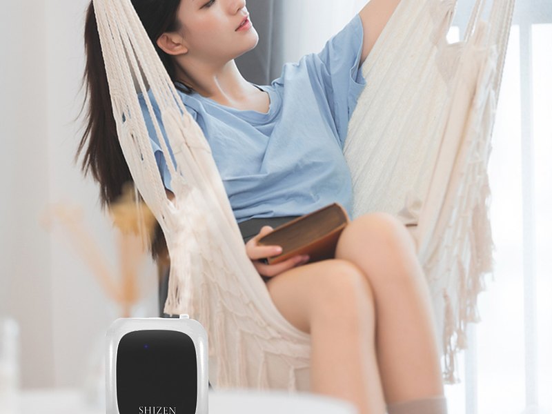本を手にハンモックでくつろぐ若い女性と、手前の小さなテーブルに置かれたShizen SBX1